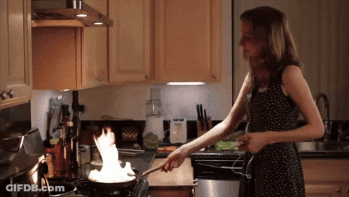 Woman Cooking On Stove With Flames From Pan GIF