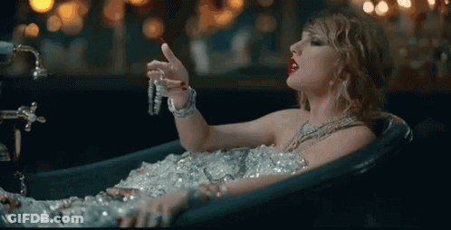 Woman Covered In Ice In Bathtub Holding Necklace GIF