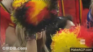 Woman Covered In Yellow And Red Feathers On Ground GIF