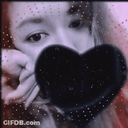 Woman Covering Face With Black Heart-Shaped Object GIF
