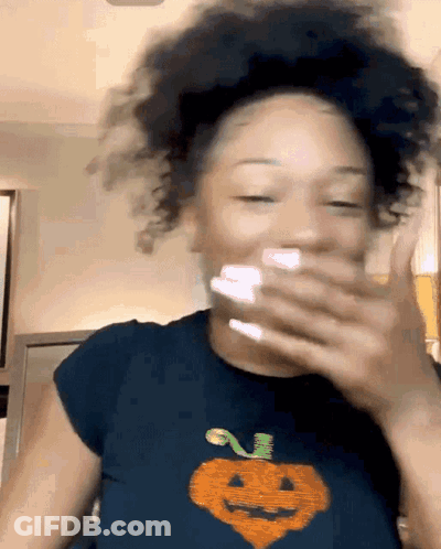 Woman Covering Mouth Wearing Pumpkin Shirt GIF
