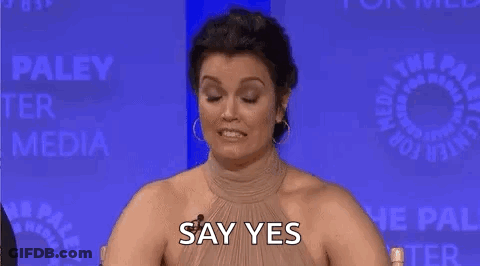 Woman Covering Nose And Smiling At Table GIF