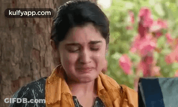 Woman Crying In Front Of Tree And Flowers GIF