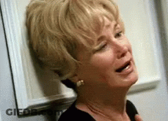 Woman Crying Leaning Against Wall GIF