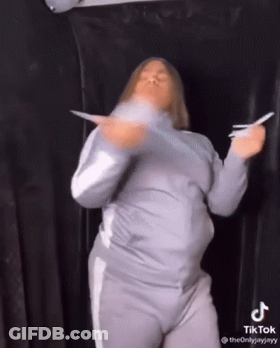 Woman Dancing Holding Paper In Front Of Black Curtain GIF