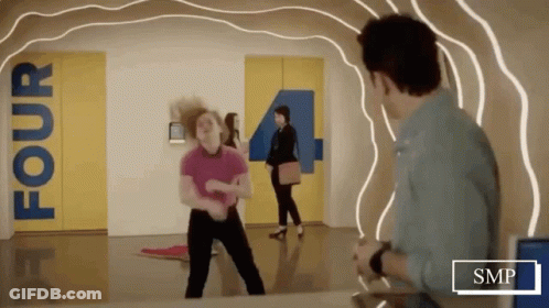 Woman Dancing In Hallway With Sign Saying Four GIF