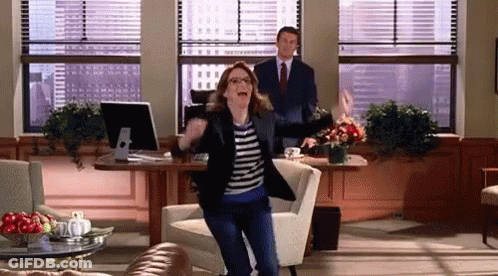 Woman Dancing In Living Room In Front Of Man In Suit GIF