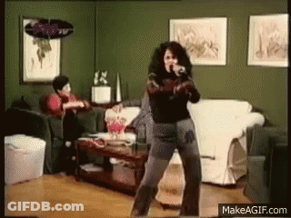 Woman Dancing In Living Room Man Sitting On Couch GIF