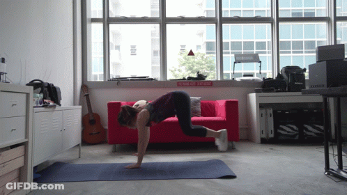 Woman Doing Push Ups By Red Couch Rock N Roll Sign GIF