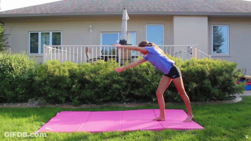 Woman Doing Yoga On Pink Mat In Front Of House GIF