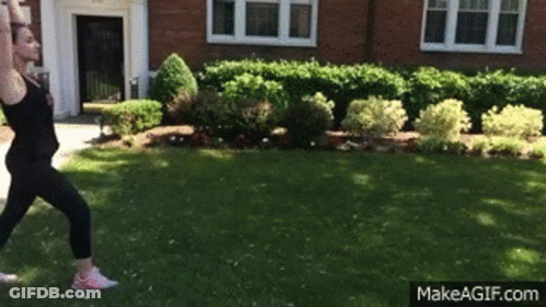Woman Doing Yoga Pose In Front Of Brick Building GIF