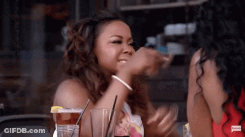 Woman Drinking At Table Beside Another Woman GIF