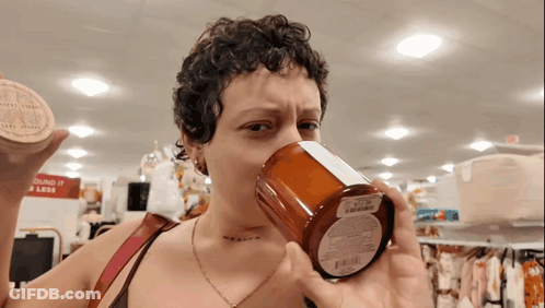 Woman Drinking From Candle In Front Of Sound It Is Less Sign GIF