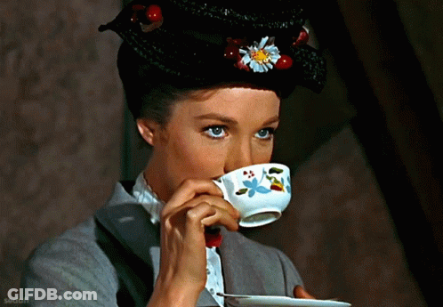 Woman Drinking From Cup With Flower On Hat GIF