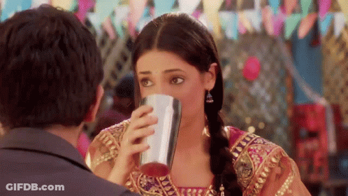 Woman Drinking From Metal Cup Looking At Man GIF