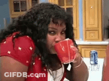 Woman Drinking From Red Cup In Kitchen GIF