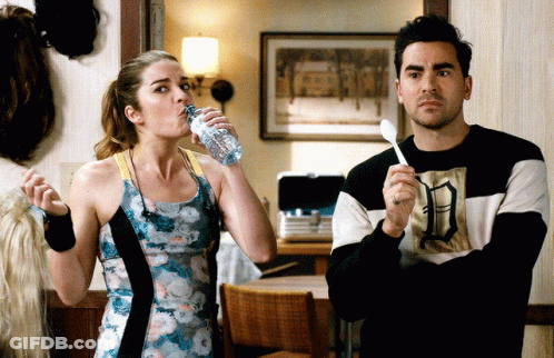 Woman Drinking Water Next To Man With Spoon GIF