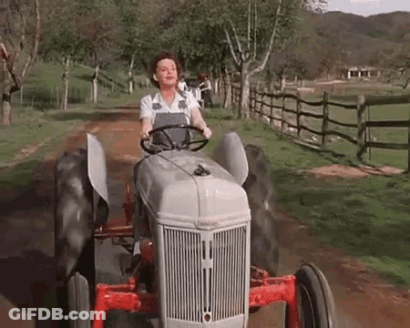 Woman Driving Tractor On Dirt Road GIF