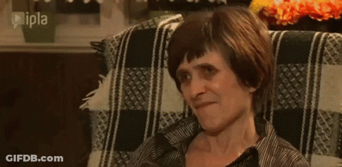 Woman Eating Apple From Man's Hand On Couch GIF
