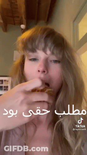 Woman Eating Hamburger With Arabic Writing GIF