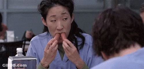 Woman Eating Hot Dog Next To Man In Restaurant GIF