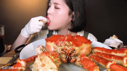 Woman Eating Large Crab GIF