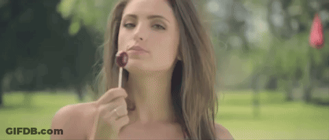 Woman Eating Lollipop In Park GIF