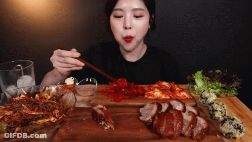 Woman Eating Meat And Vegetables With Chopsticks GIF