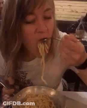 Woman Eating Noodles From Bowl With Fork GIF