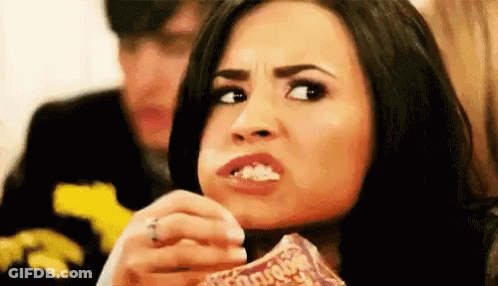Woman Eating Popcorn Making Funny Face While Man Looks On GIF