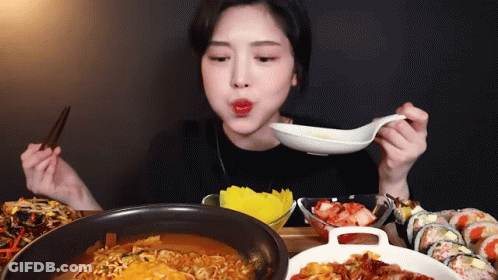 Woman Eating Ramen And Sushi With Chopsticks And Spoon GIF