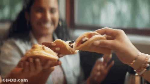 Woman Eating Sandwich While Another Holds One GIF