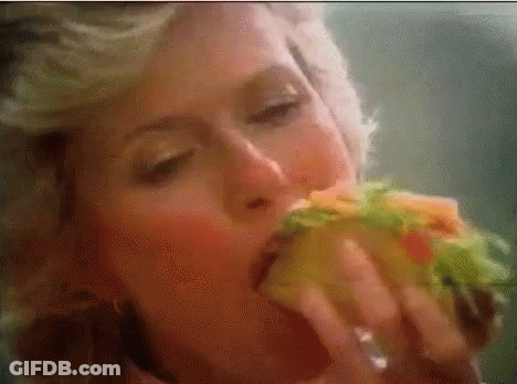 Woman Eating Sandwich With Eyes Closed GIF