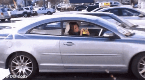 Woman Eating Snack In Car GIF