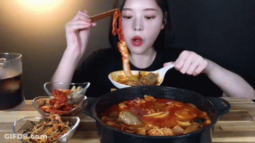 Woman Eating Stew With Spoon And Chopsticks GIF