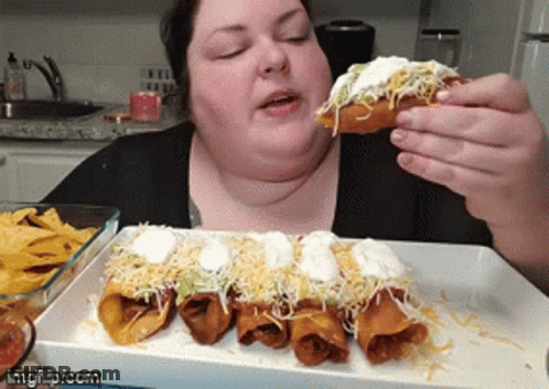 Woman Eating Taco With Sour Cream And Cheese GIF