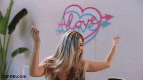 Woman Flexing Muscles By Heart Wall With Love GIF