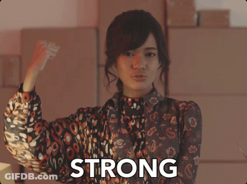 Woman Flexing Muscles In Front Of Strong Sign GIF