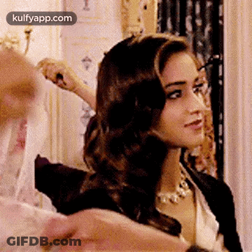 Woman Getting Hair Done By Man Looking At Camera GIF