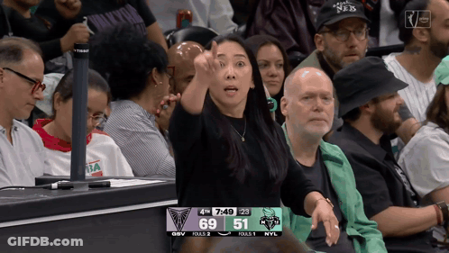 Woman Giving Thumbs Up In Front Of Scoreboard 69 And 51 GIF