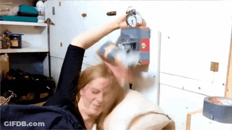 Woman Holding Alarm Clock In Bed GIF