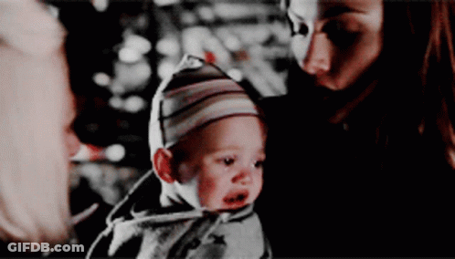 Woman Holding Baby In Striped Hat GIF