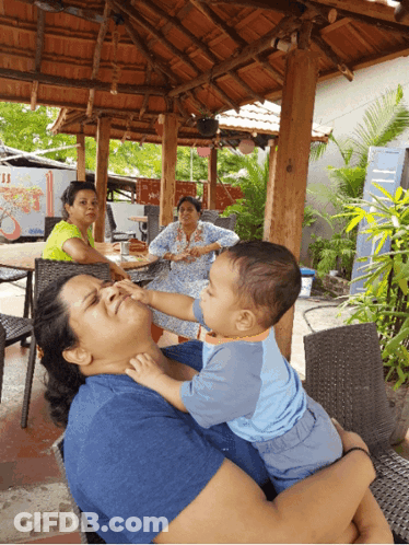Woman Holding Baby Reaching For Face GIF