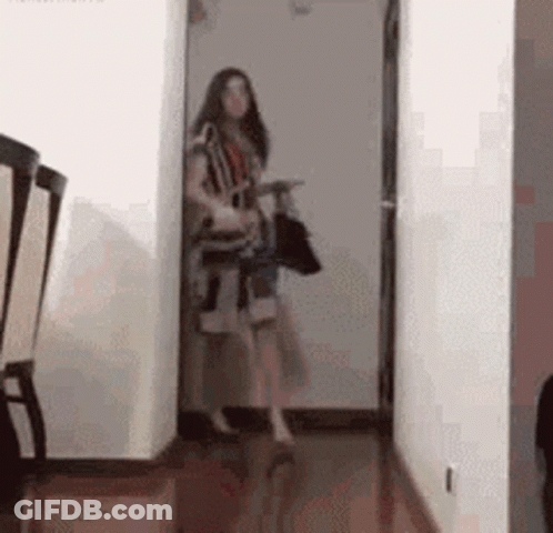Woman Holding Bag And Purse In Hallway GIF