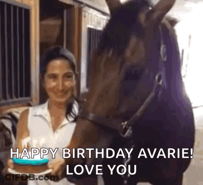 Woman Holding Birthday Cake In Front Of Horse In Barn GIF