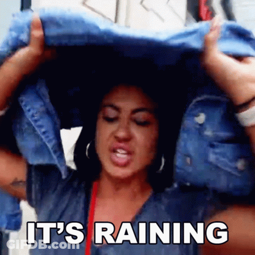Woman Holding Blue Jacket Over Head Saying It's Raining GIF