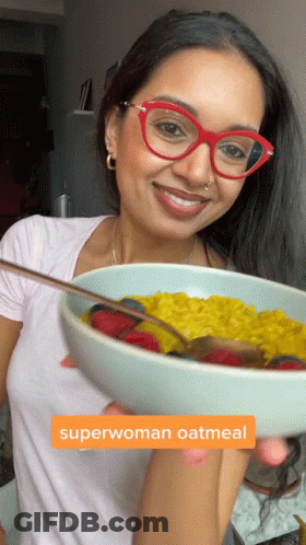 Woman Holding Bowl Of Superwoman Oatmeal With Strawberries And Blueberries GIF