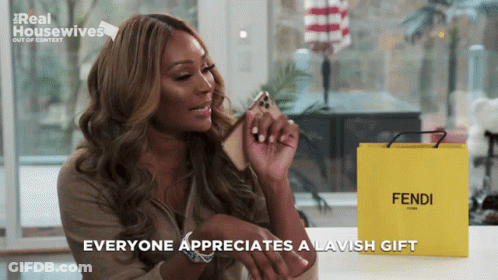 Woman Holding Cell Phone Next To Yellow Bag Saying Fendi GIF