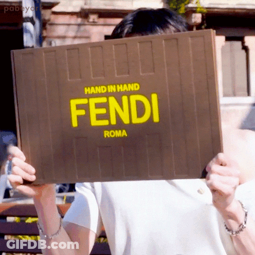 Woman Holding Cell Phone Next To Yellow Fendi Bag GIF