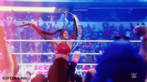 Woman Holding Championship Belt In Wrestling Ring With Crowd GIF